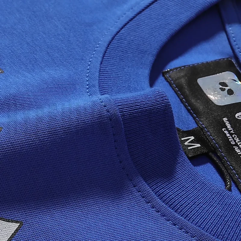 Detailed close-up of the tee's neck label, featuring wash care instructions and subtle brand branding in a clean, minimalist typography