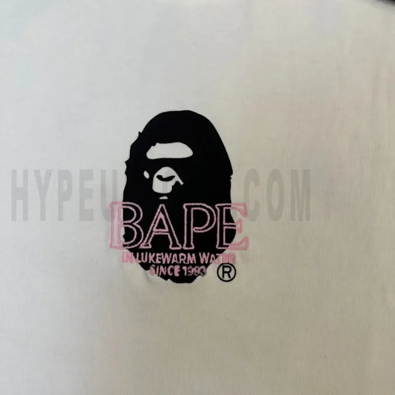 Detailed shot capturing the graphic print on the white tee's front panel.