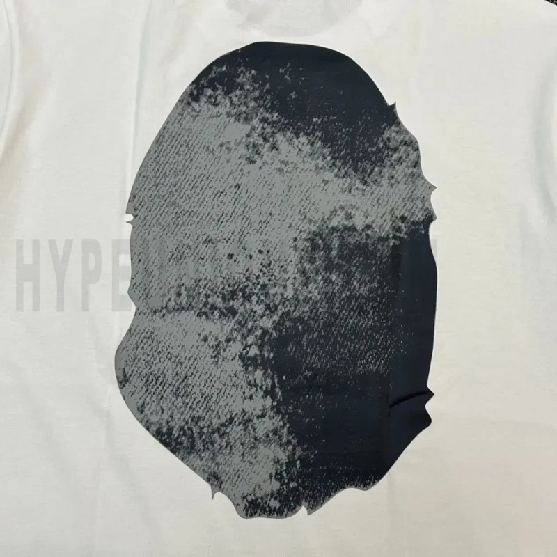 Detailed shot capturing the graphic print on the white tee's back panel.