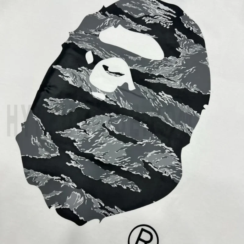 Detailed shot capturing the graphic print on the white tee's front panel.