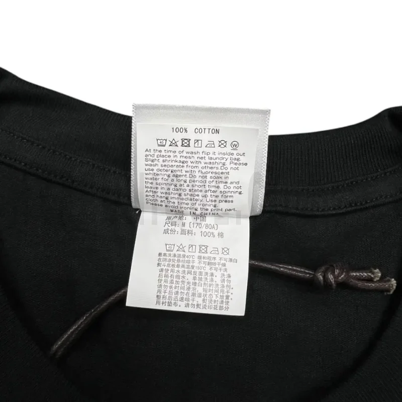 Close-up detail of the neck tag, showcasing care instruction icons and elevated brand labeling—designed with a contemporary aesthetic edge.