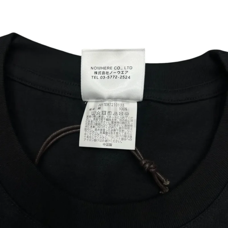 Close-up detail of the neck tag, showcasing care instruction icons and elevated brand labeling—designed with a contemporary aesthetic edge.