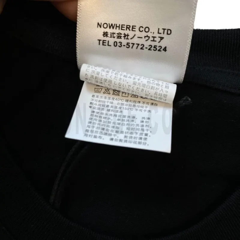 Neckline tag close-up, displaying garment care symbols and brand information with fashion-forward presentation.