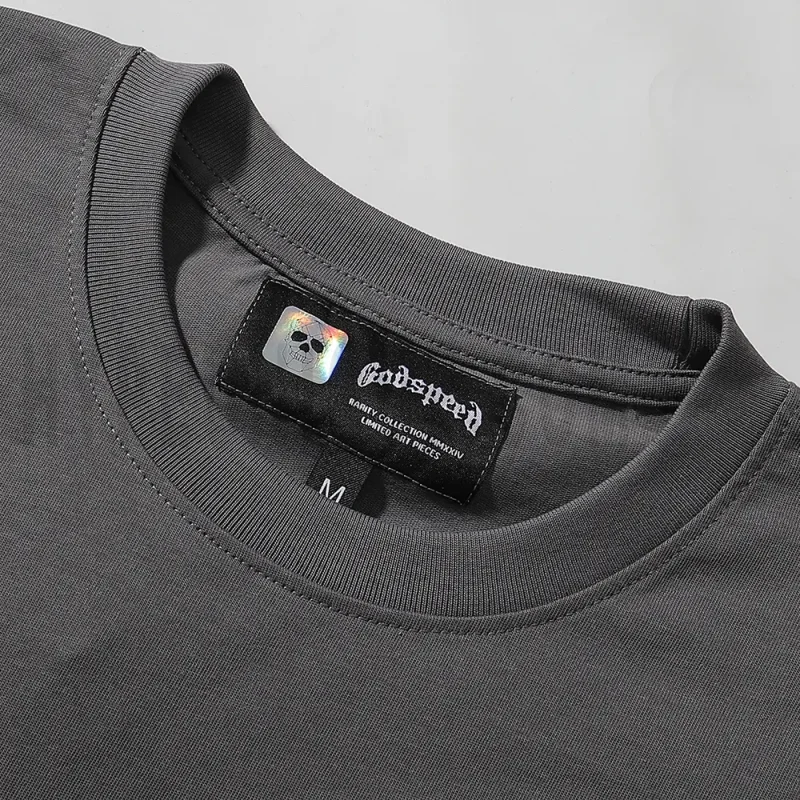Close-up of the T-shirt's neckline tag, showcasing wash care instructions and brand details in a fashion design.