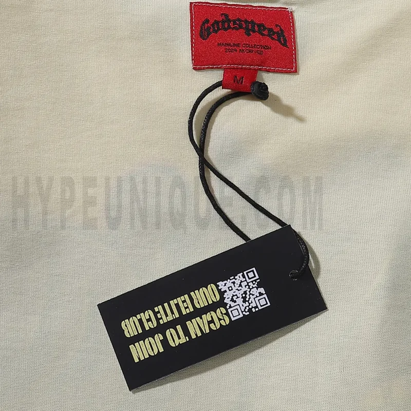Close-up of the tee's featuring wash care instructions and subtle brand branding in a clean, minimalist typography