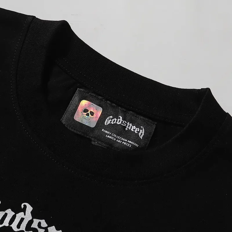 Detailed close-up of the tee's neck label, featuring wash care instructions and subtle brand branding in a clean, minimalist typography
