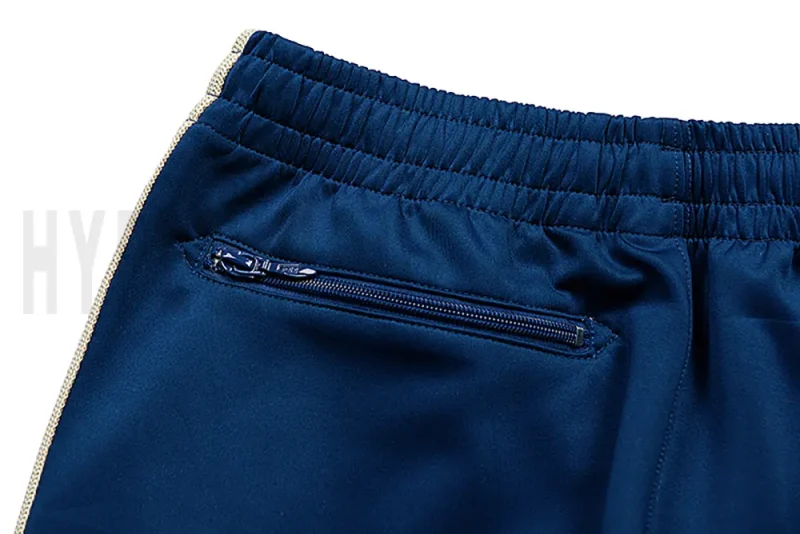 Detail of the back zip pocket on the track pants.