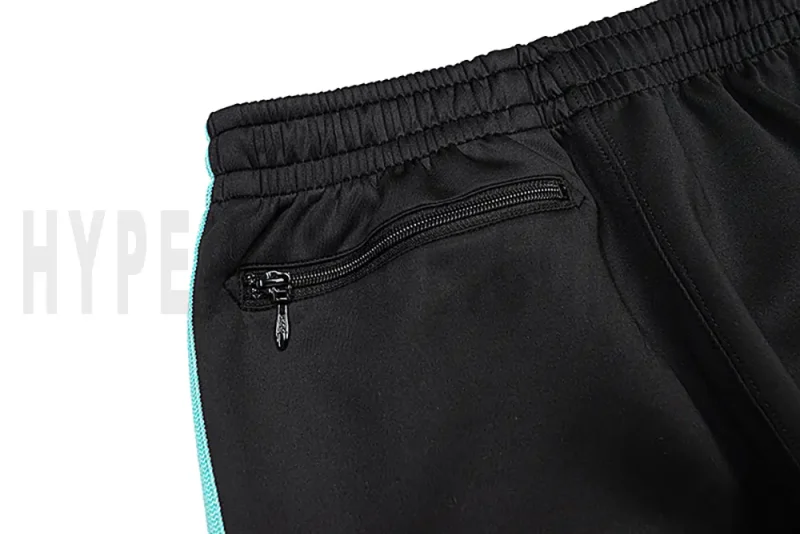 Detail of the back zip pocket on the track pants.