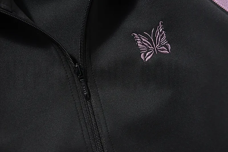 Close-up of butterfly embroidery detail on the chest of the jacket.