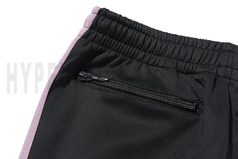 Detail of the back zip pocket on the track pants.