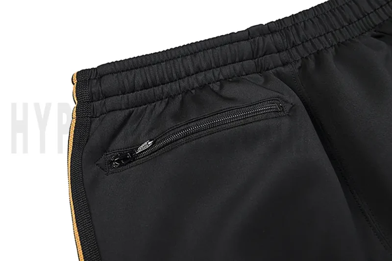 Detail of the back zip pocket on the track pants.
