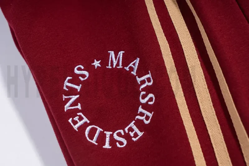 White signature embroidered logo on the red pants.