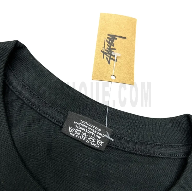 Detailed shot of the garment's neck tag, featuring fabric care icons and designer information in a fashion-conscious layout.